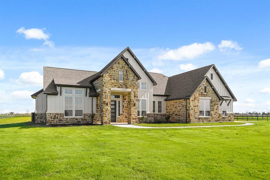 This high-end custom home has an abundance of fine finishes that set it apart from the rest. This angle highlights the gabled roofing and its inset soffit lighting that masterfully illuminates the home every evening