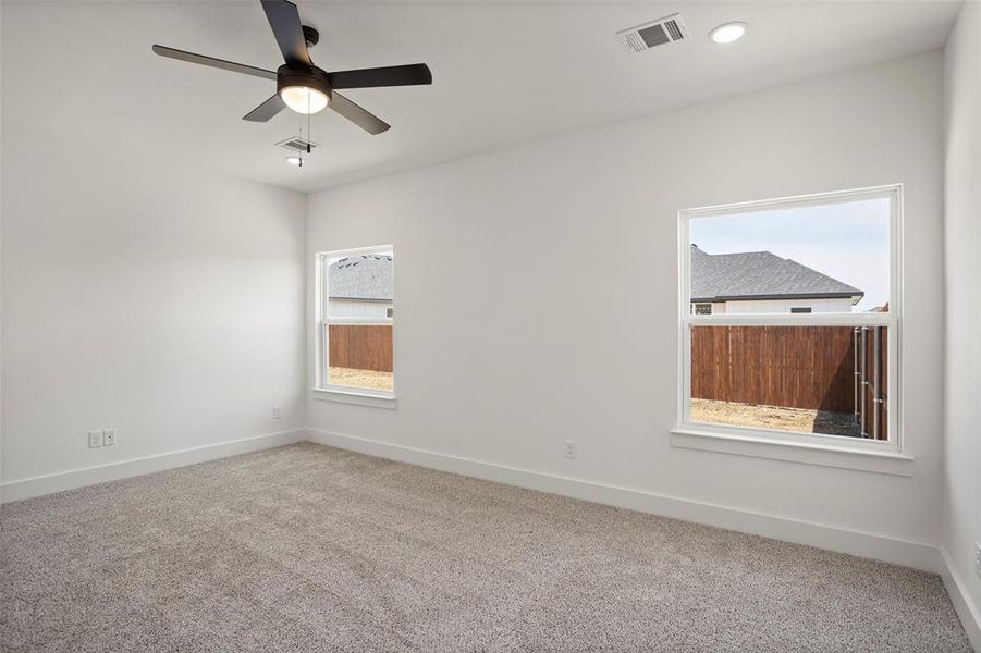 Unfurnished room featuring carpet floors and ceiling fan