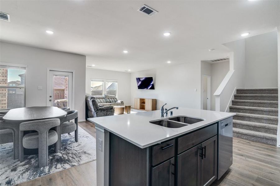 Kitchen with open floor plan, a kitchen island with sink, stainless steel dishwasher, light wood finished floors, and recessed lighting Kitchen with open floor plan, a kitchen island with sink, stainless steel dishwasher, light wood finished floors, and recessed lighting