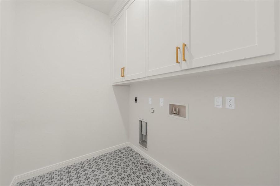 Washroom featuring gas dryer hookup, washer hookup, cabinet space, tile patterned floors, and electric dryer hookup Washroom featuring gas dryer hookup, washer hookup, cabinet space, tile patterned floors, and electric dryer hookup
