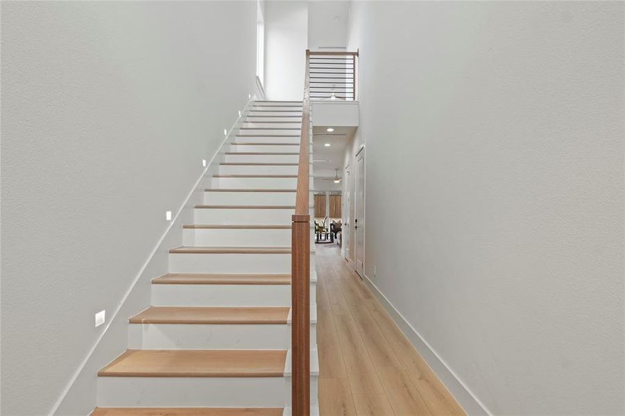 Stairway with wood finished floors and a high ceiling Stairway with wood finished floors and a high ceiling