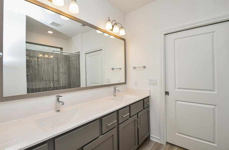 Primary bathroom double sink with extra counter space and a beautiful custom mirror