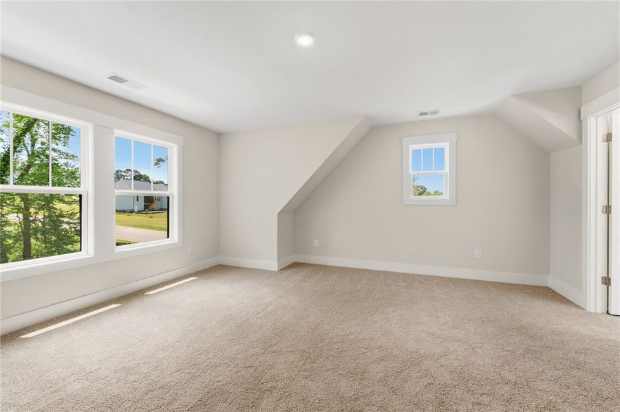 A spacious bedroom offers comfort with soft carpet