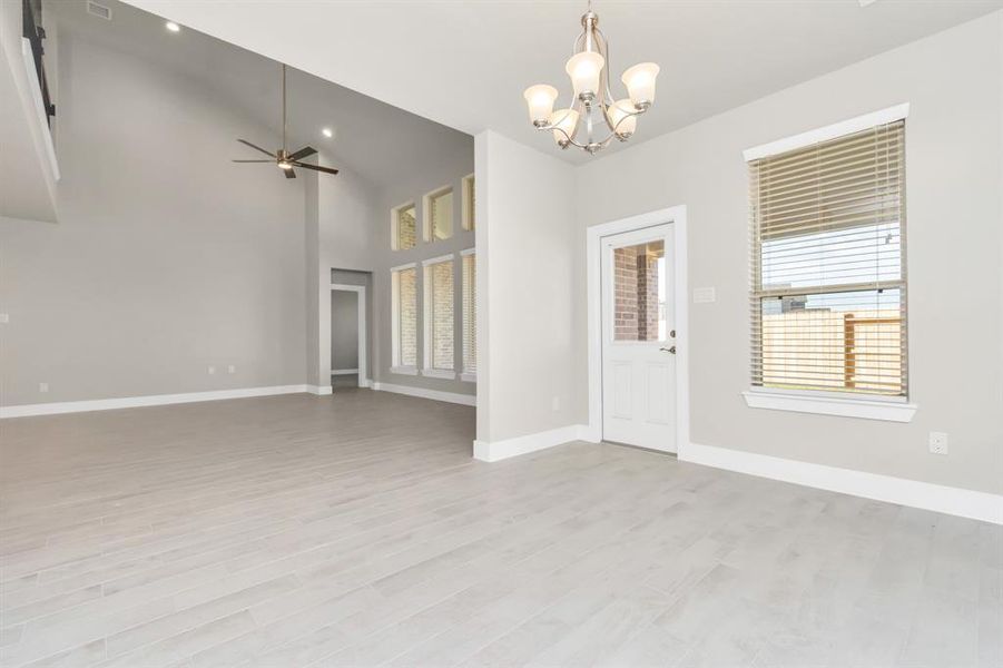 This seamless open concept ensures a connected flow between the family room, kitchen, and this dining area. The back door, adorned with a window for natural light, opens gracefully to the covered patio. Actual interior color and selections may vary. Sample photo of completed home with similar floor plan. As-built interior colors and selections may vary.