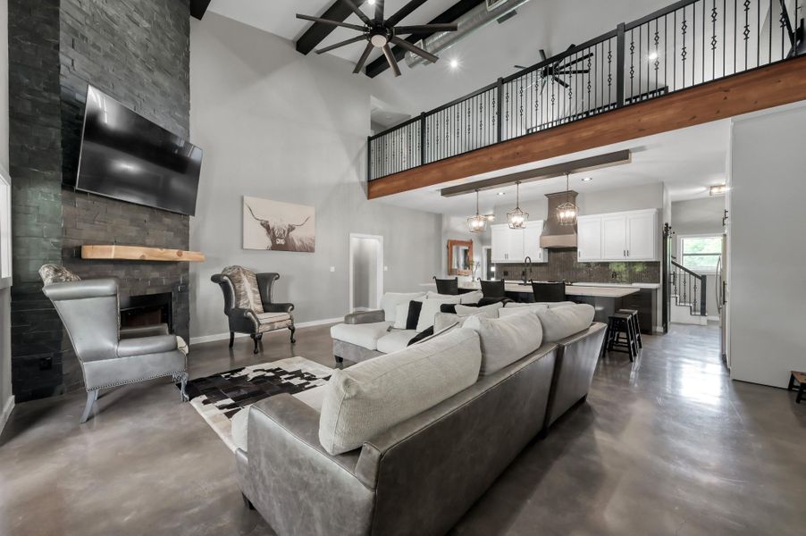 Natural light streams in through multiple windows, enhancing the sleek concrete floors.