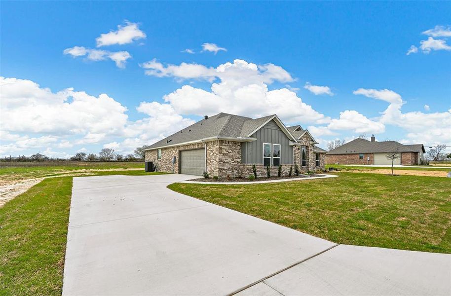 View of front facade with a garage and a front lawn