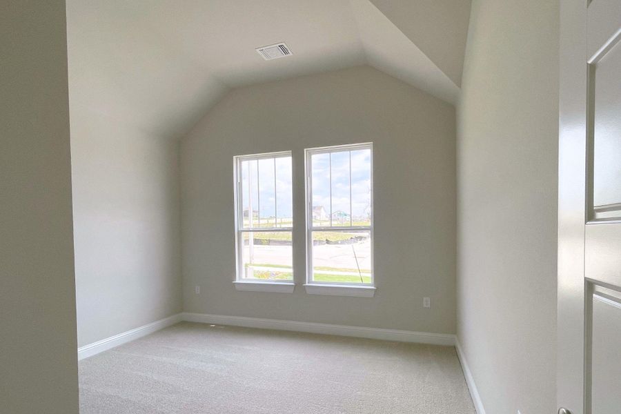 Tall vaulted ceilings and generous window light illuminate this versatile room, awaiting personal touches.