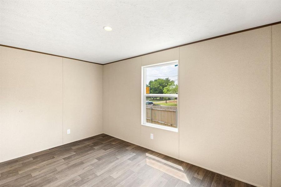 Interior room featuring wood-finish flooring, a single pane window, and recessed lighting
