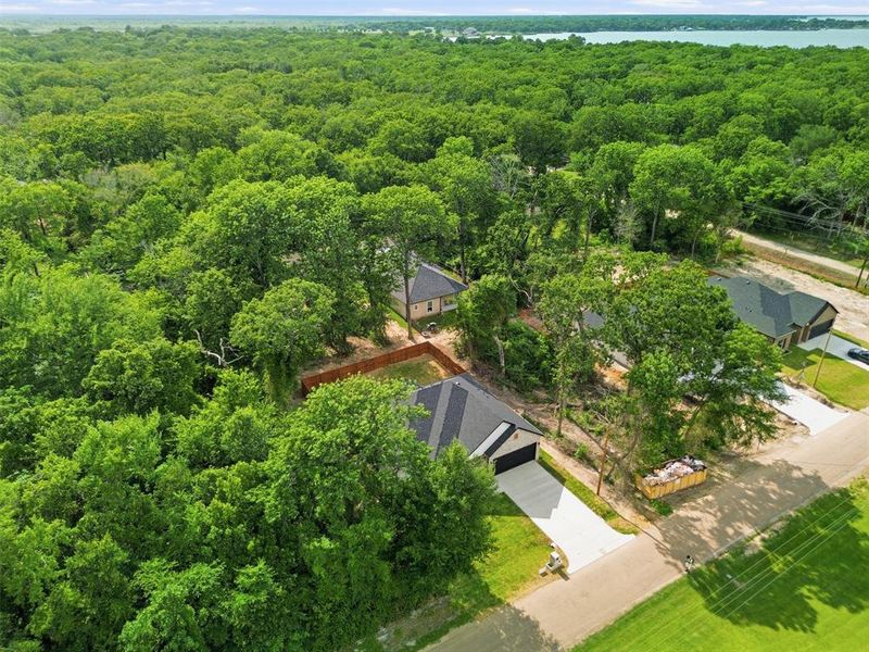 New construction home featuring a dark shingled roof, light-colored driveway, and attached garage