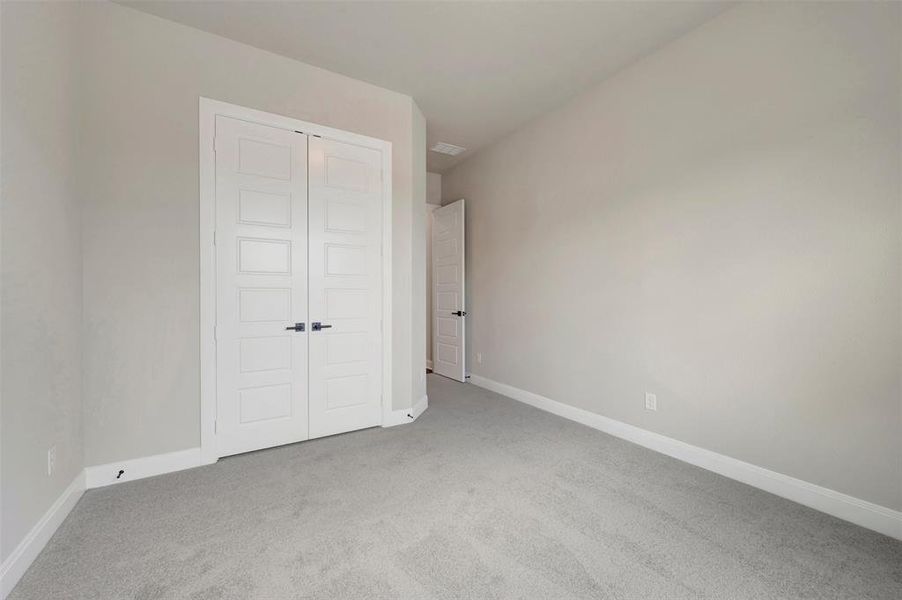 Neutral-toned room featuring light gray carpeting and light gray wall paint