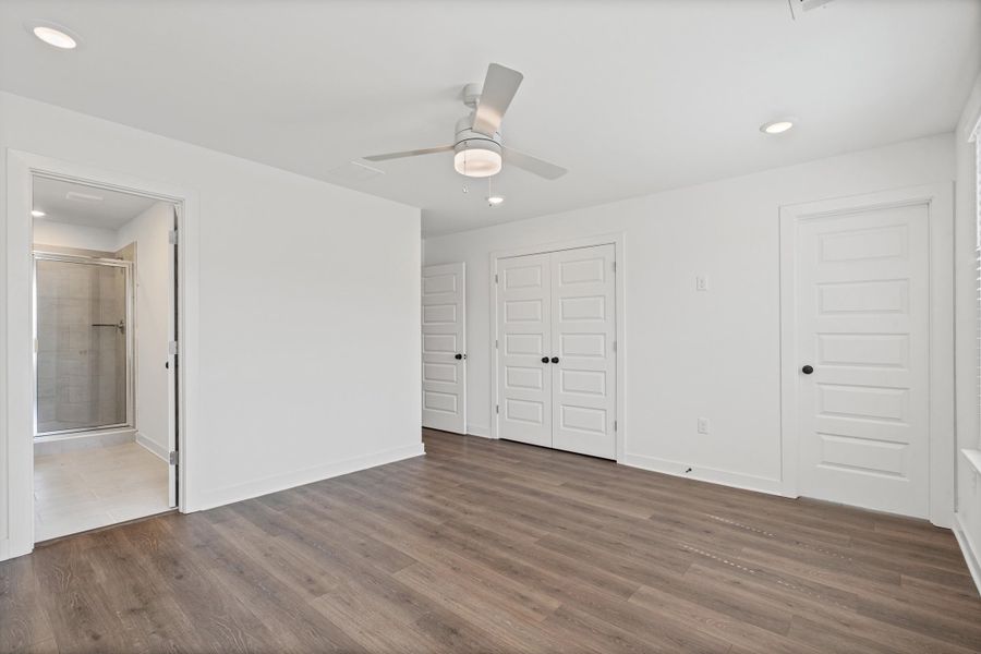 Spacious room with wood-finish flooring, recessed lighting, and a ceiling fan