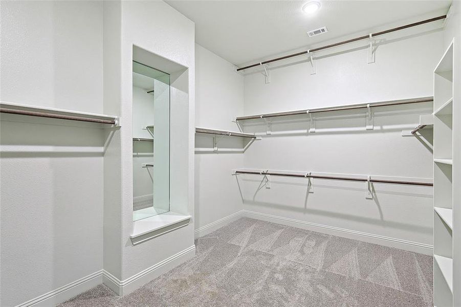 Walk in closet with light colored carpet