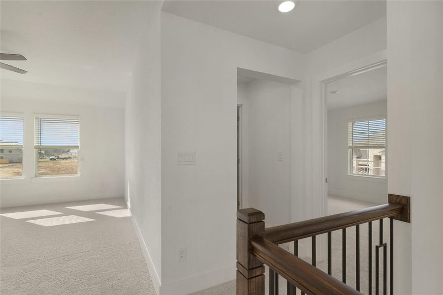 Hall featuring an upstairs landing and carpet floors