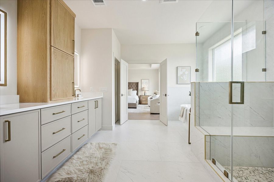 Beautiful from every angle, the owner’s ensuite pairs an oversized glass shower, freestanding soaking tub and long custom vanity with elegant finishes and easy access to two custom walk-in closets.