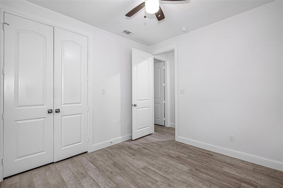 Unfurnished bedroom featuring light wood-type flooring, baseboards, a closet, and a ceiling fan Unfurnished bedroom featuring light wood-type flooring, baseboards, a closet, and a ceiling fan