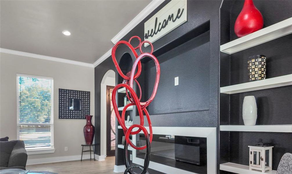 Detailed view of ornamental molding, wood finished floors, arched walkways, and recessed lighting