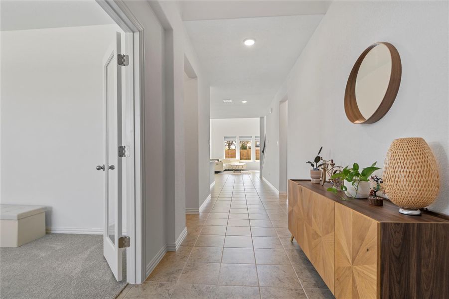 A welcoming entryway hallway with tile flooring leads to an open living space. A welcoming entryway hallway with tile flooring leads to an open living space.