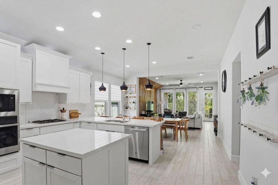 A bright, workspace-focused kitchen offering stainless steel appliances, plenty of prep space and pantry.
