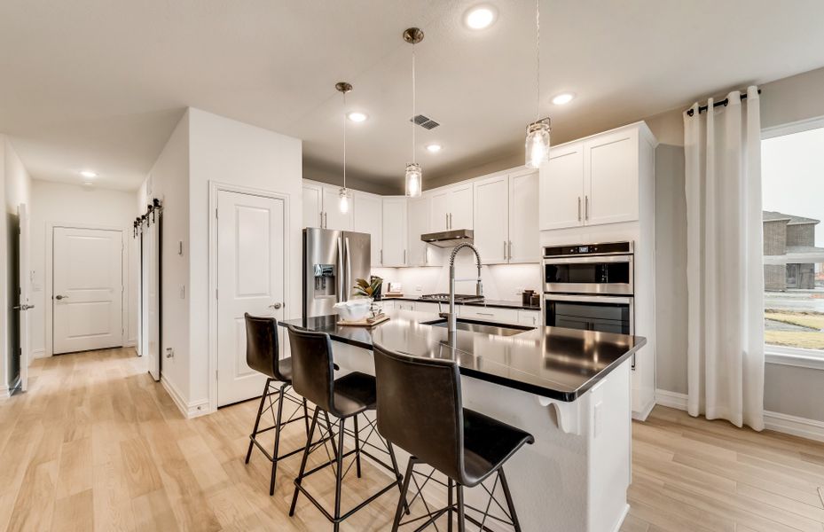 Spacious island kitchen with recessed and pendant