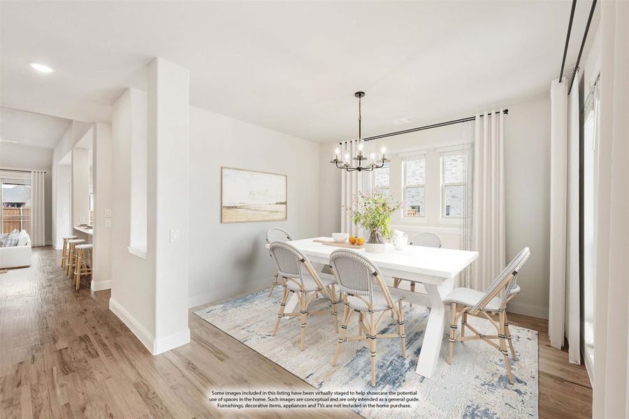 Dining room with white table, rattan chairs, chandelier, and hardwood floors
