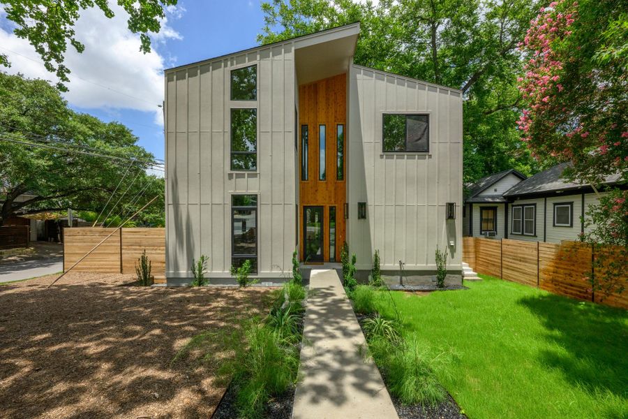 A striking modern facade with clean lines and a soaring wood entry greets guests. A striking modern facade with clean lines and a soaring wood entry greets guests.