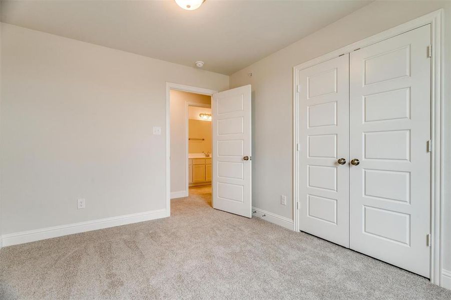 Unfurnished bedroom featuring light colored carpet and a closet