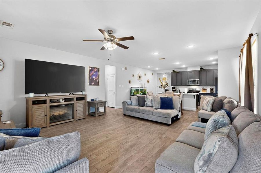 Living room featuring ceiling fan, light wood-style flooring, and recessed lighting Living room featuring ceiling fan, light wood-style flooring, and recessed lighting