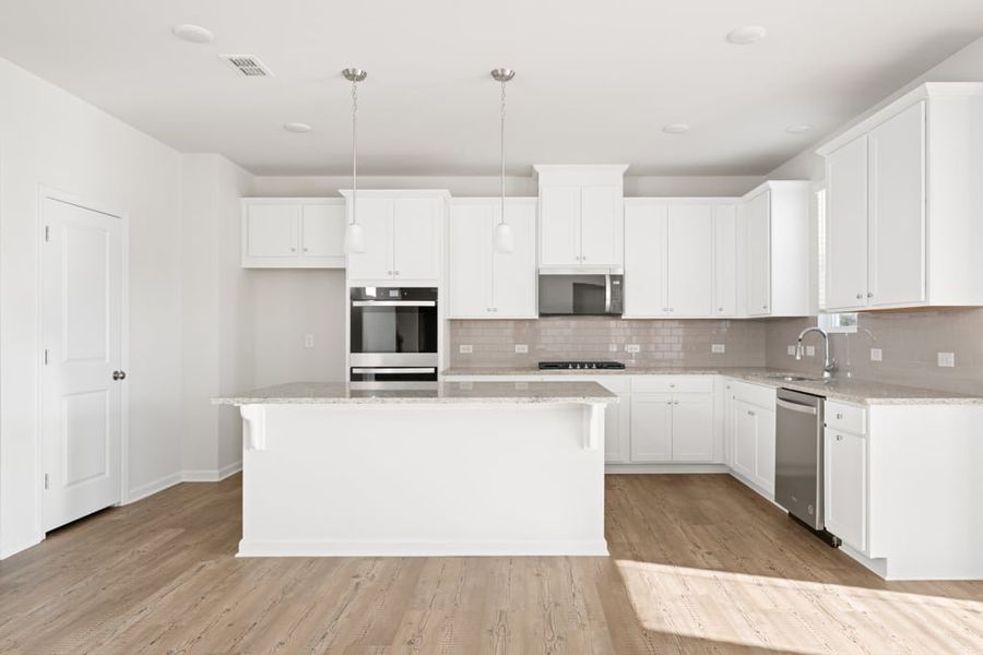 A kitchen with white cabinets.