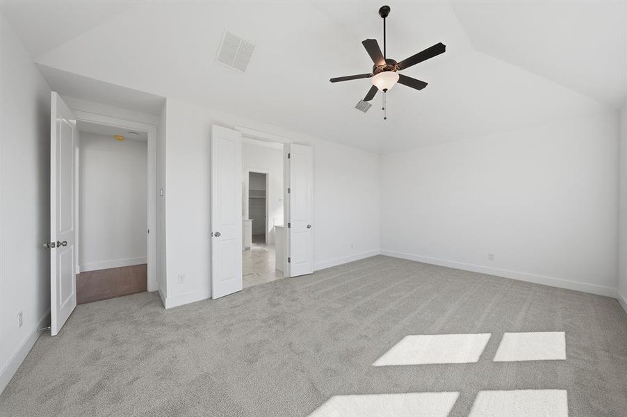 Unfurnished bedroom featuring light carpet and a ceiling fan Unfurnished bedroom featuring light carpet and a ceiling fan