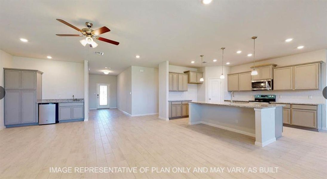 Kitchen with light stone counters, stainless steel appliances, ceiling fan, a sink, and open floor plan Kitchen with light stone counters, stainless steel appliances, ceiling fan, a sink, and open floor plan