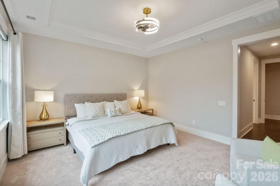 Primary Bedroom-Level 1. Tray Ceiling, large picture window, electronic roller shades