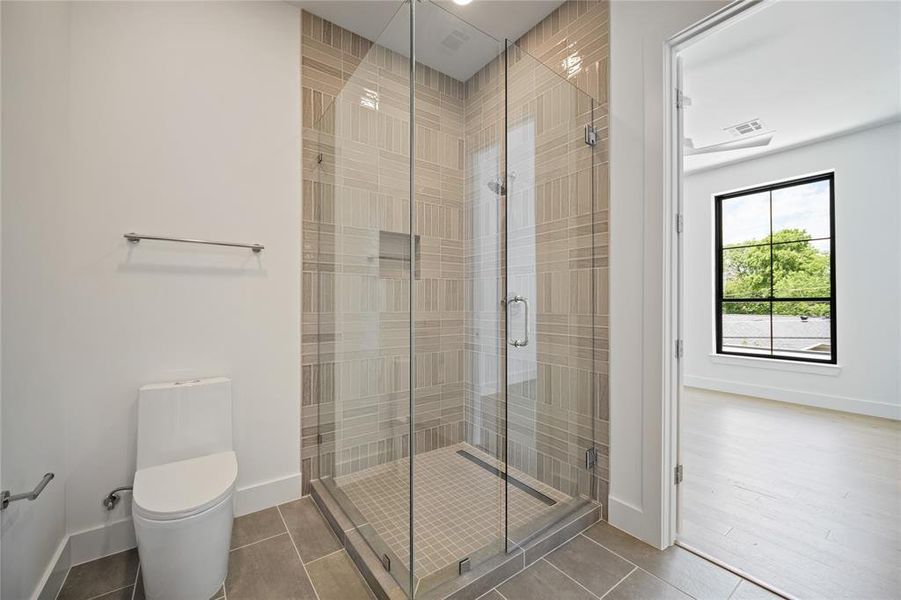 Full bath featuring a shower stall and tile patterned flooring
