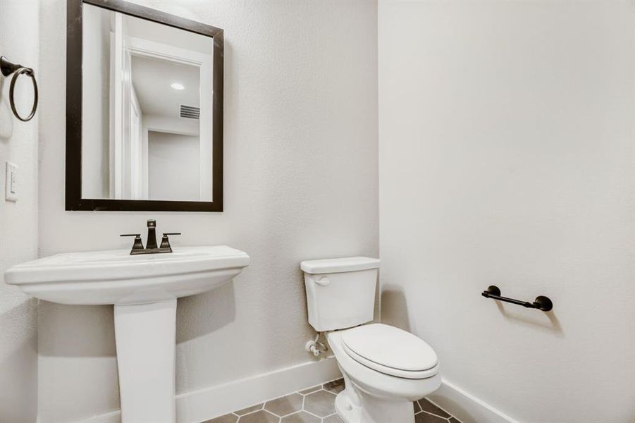 Half bath featuring toilet and tile patterned flooring