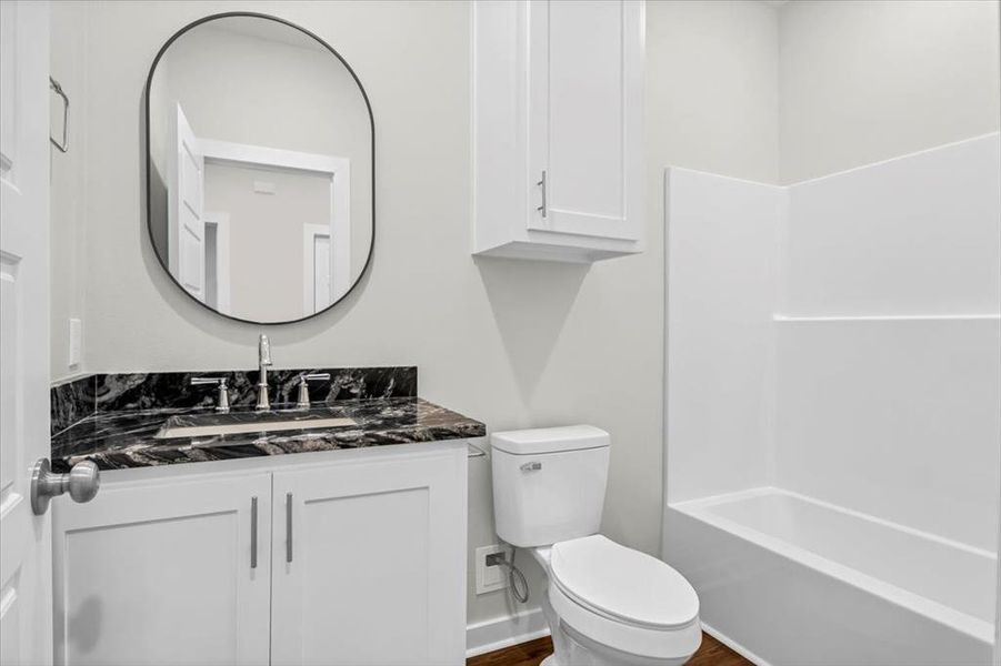 Bathroom with toilet, vanity, and wood finished floors