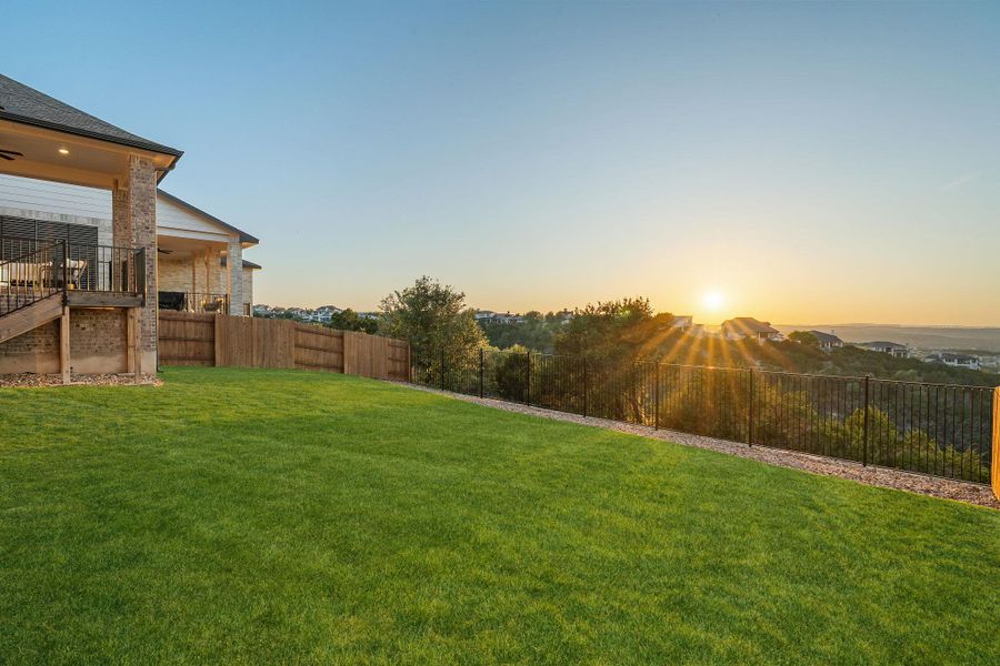 Expansive terraced yard with a stone and wood-clad exterior, covered patio, and wood privacy fencing Expansive terraced yard with a stone and wood-clad exterior, covered patio, and wood privacy fencing