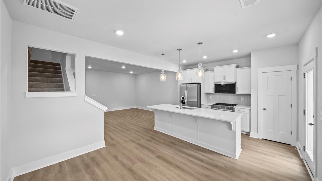 Tasteful design meets functional luxury in this kitchen with a 9-foot island and modern pendant lighting in Piedmont, SC