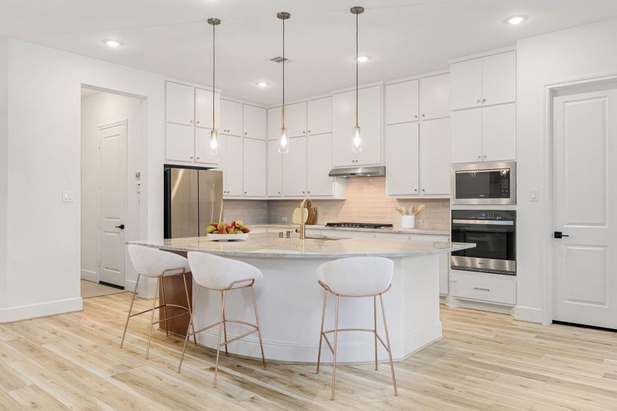 An inviting kitchen showcases white cabinetry, generous counter space, and a large island that anchors the open floor plan.