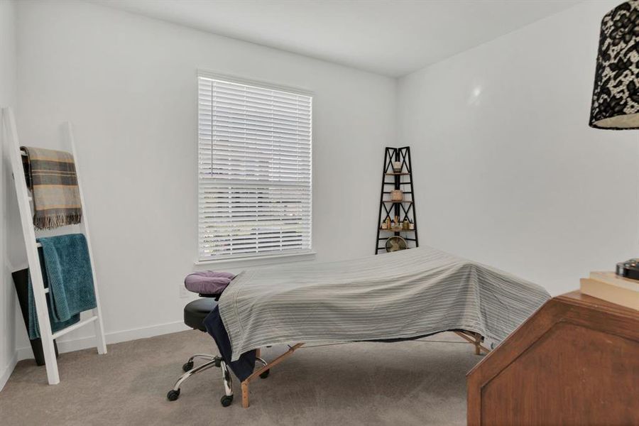 Bedroom featuring carpet and baseboards