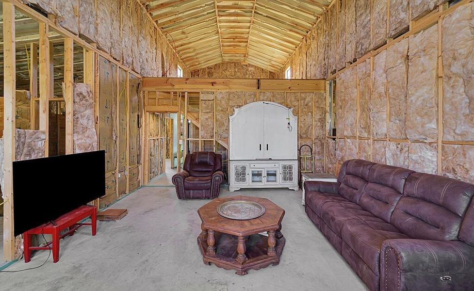Living area with lofted ceiling and concrete floors Living area with lofted ceiling and concrete floors