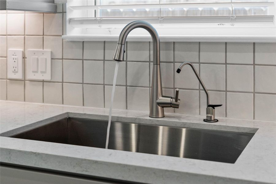 The kitchen features a stainless steel undermount sink and a Moen Sleek satin nickel kitchen faucet with DuPure water filtration system. The kitchen features a stainless steel undermount sink and a Moen Sleek satin nickel kitchen faucet with DuPure water filtration system.