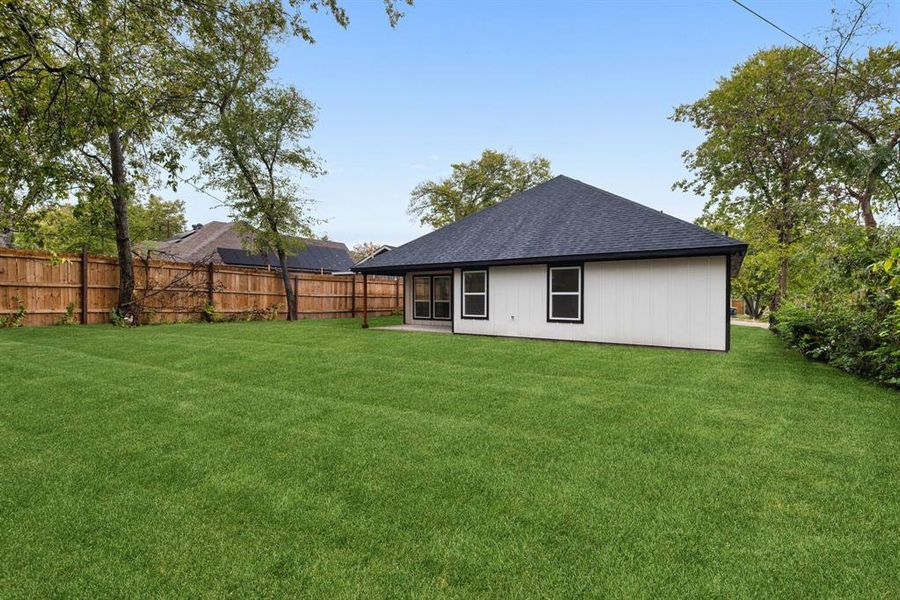 Rear view of property featuring a lawn and a patio area