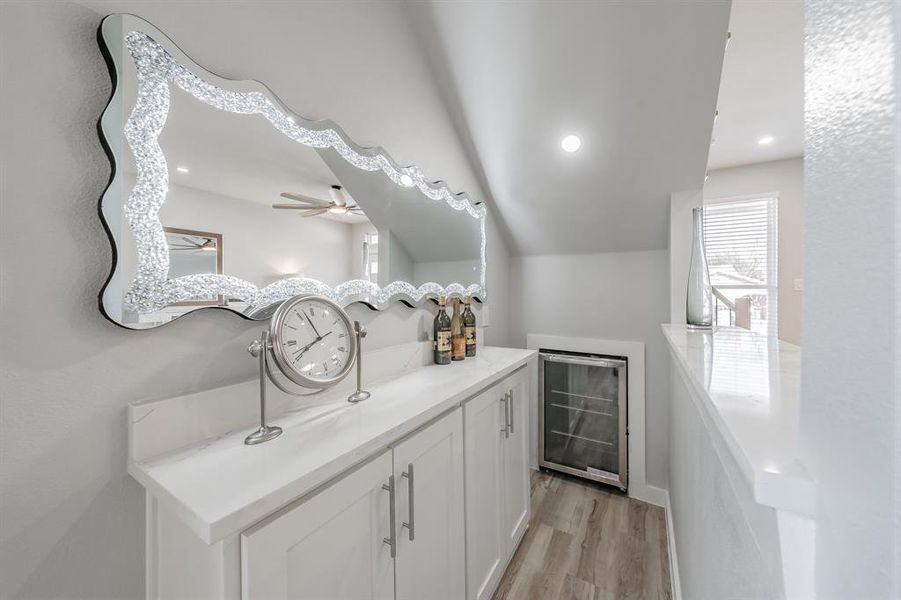 Bathroom featuring wine cooler, ceiling fan, vanity, and hardwood / wood-style floors