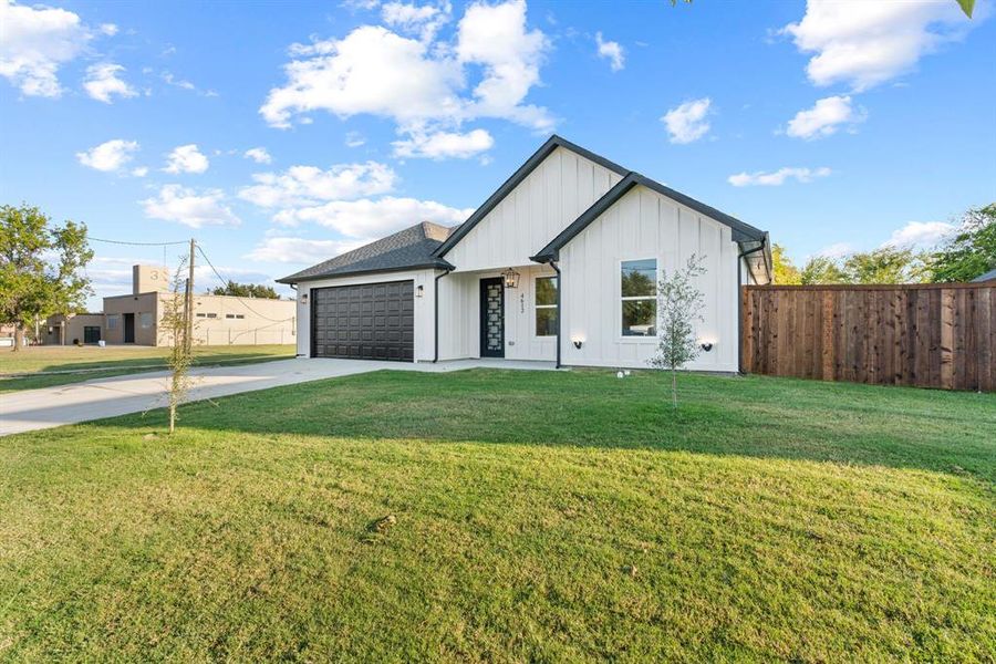 Modern farmhouse style home with a garage and a front lawn