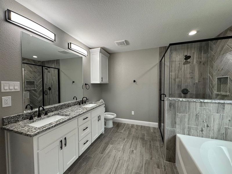 Full bathroom featuring independent shower and bath, vanity, wood-type flooring, and a textured ceiling