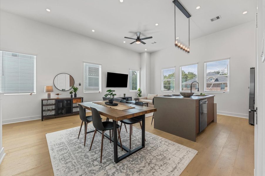 The dining area, part of the open-concept living, dining, and kitchen on the second floor, offers ample space for a large table, making it perfect for family meals or entertaining friends, while seamlessly flowing with the bright, airy atmosphere of the surrounding living space.