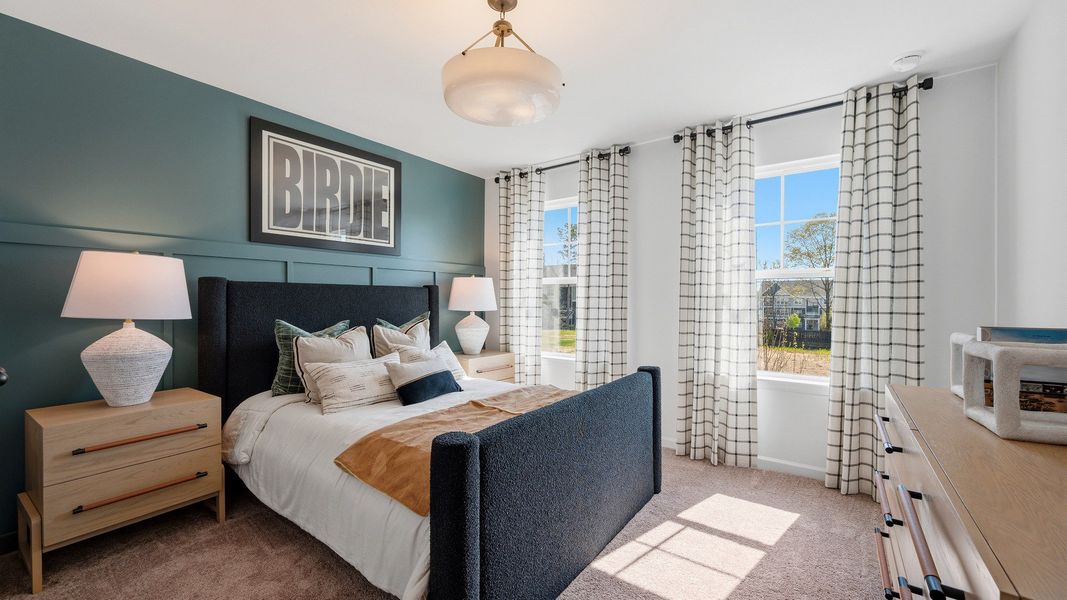 Comfortable secondary bedroom with large windows in new construction townhome at Langley Overlook in Loganville, GA.