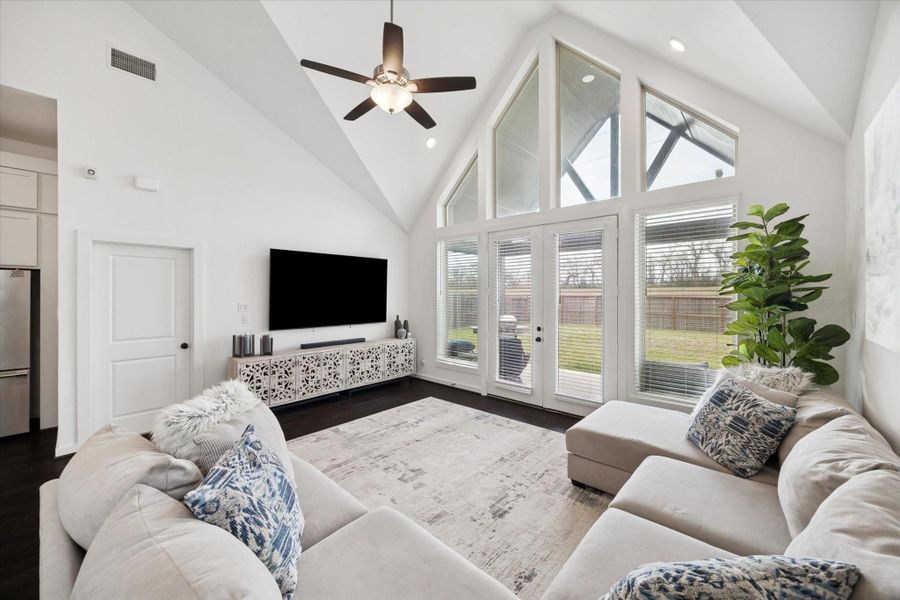 THE FAMILY ROOM FEATURES LARGE BANK OF WINDOWS AND DOORS OVERLOOKING THE BACKYARD.