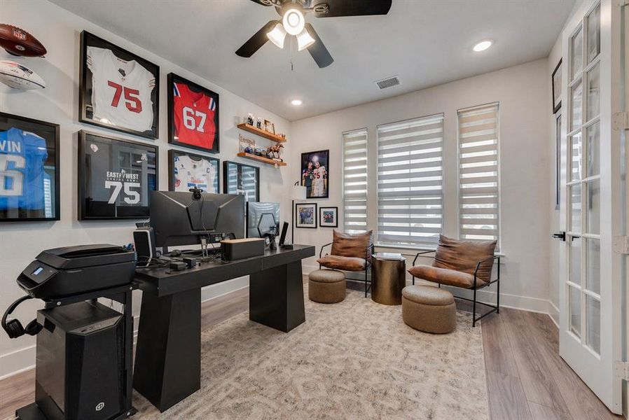 Dedicated office space featuring two large windows with blinds, a ceiling fan, recessed lighting, and wood-finish flooring