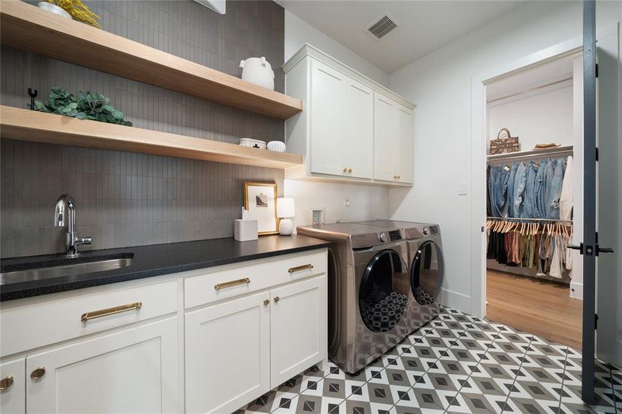 Laundry area with washer and dryer, sink, and cabinets