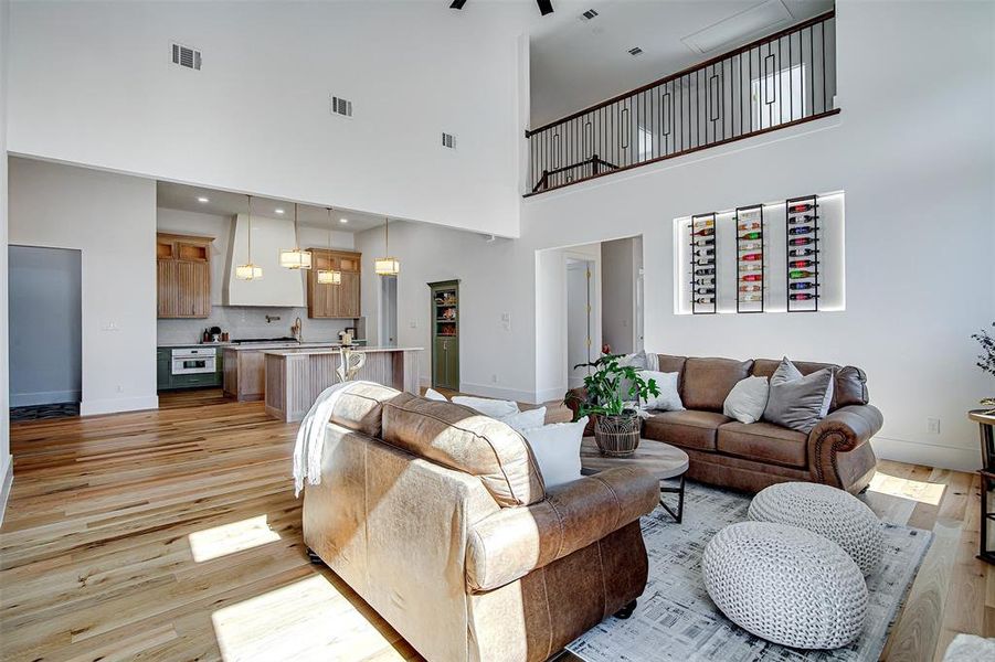 Living room with light wood finished floors and a towering ceiling Living room with light wood finished floors and a towering ceiling
